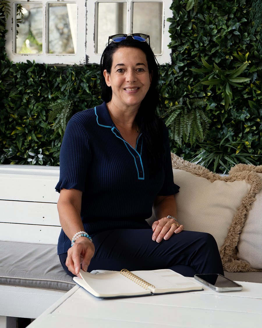 Annette Knecht Seier, founder of Own Your Stage Studio, seated with an open notebook.
