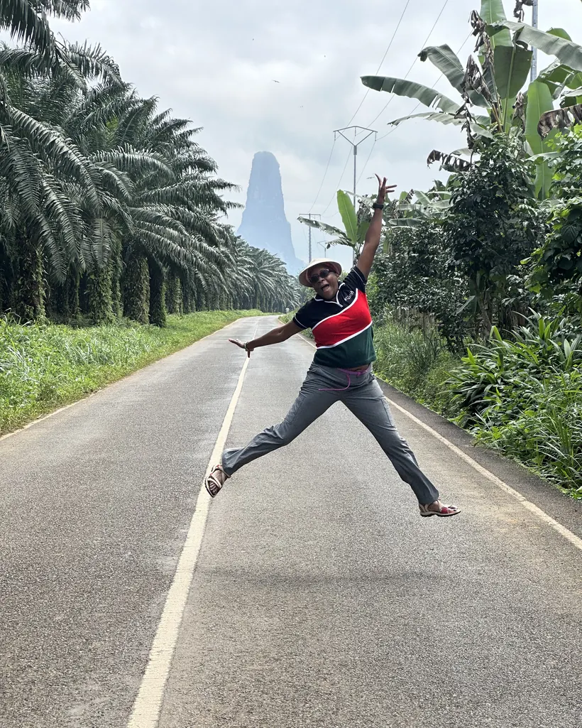 Maria jumping on a road in São Tomé and Príncipe, her 100th country